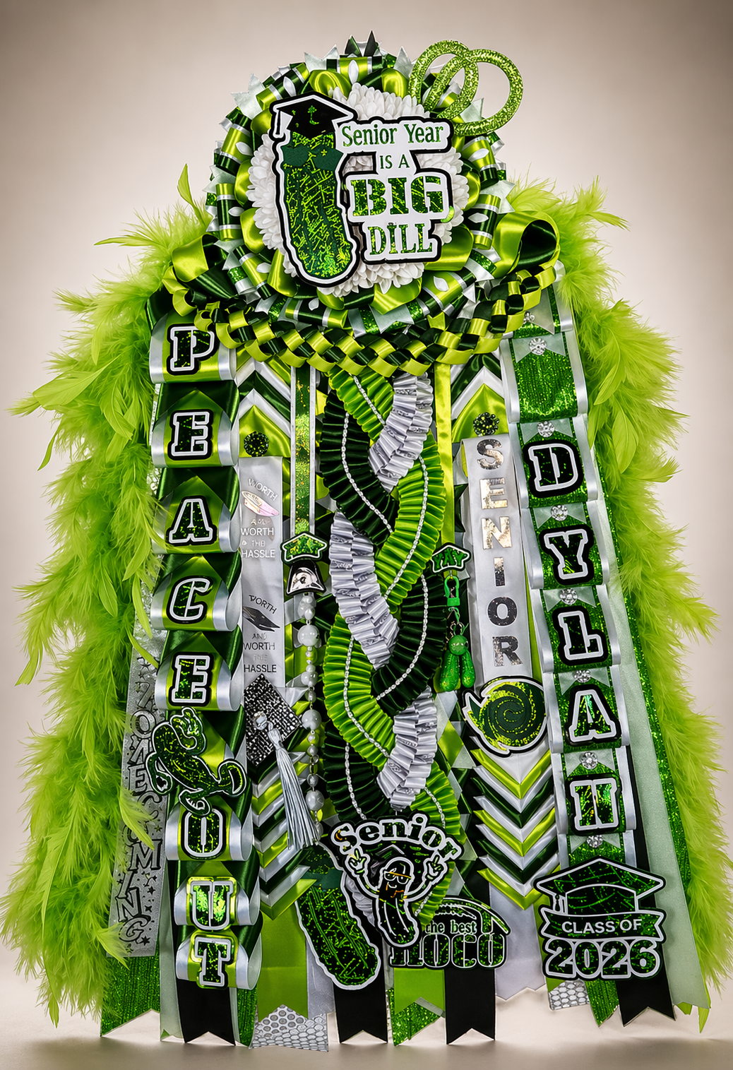 Themed green Senior 2026 homecoming mum with feather boa